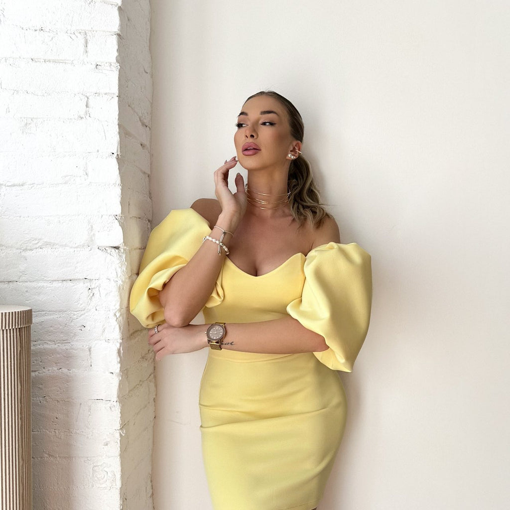yellow puff sleeve dress woman leaning on white wall yellow puff sleeve dress woman leaning on white wall