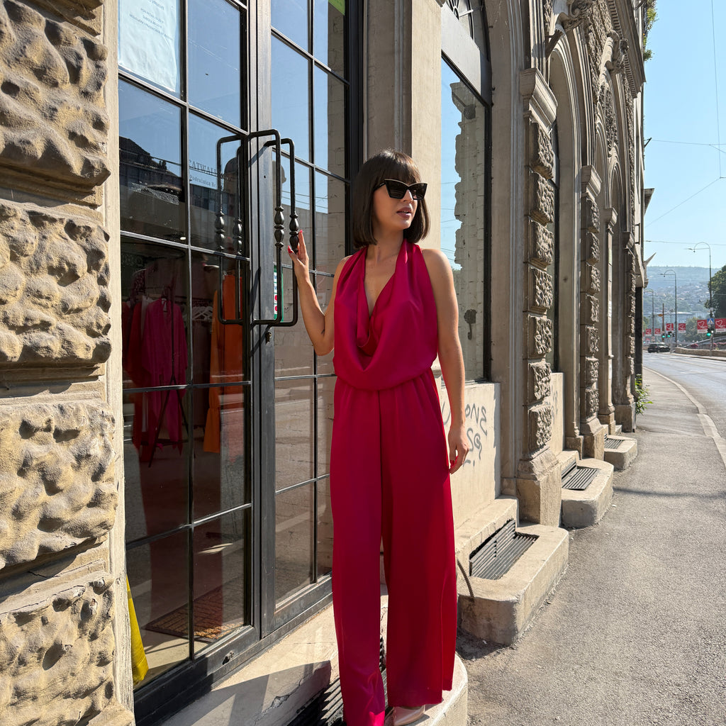 woman in pink sleeveless jumpsuit outside storefront woman in pink sleeveless jumpsuit outside storefront