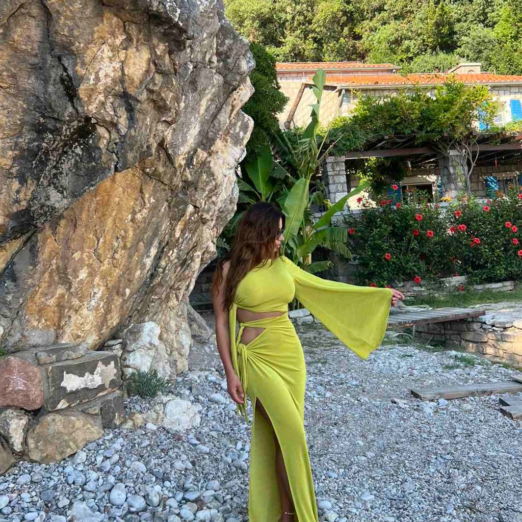 woman in olive green one shoulder dress on rocky beach woman in olive green one shoulder dress on rocky beach