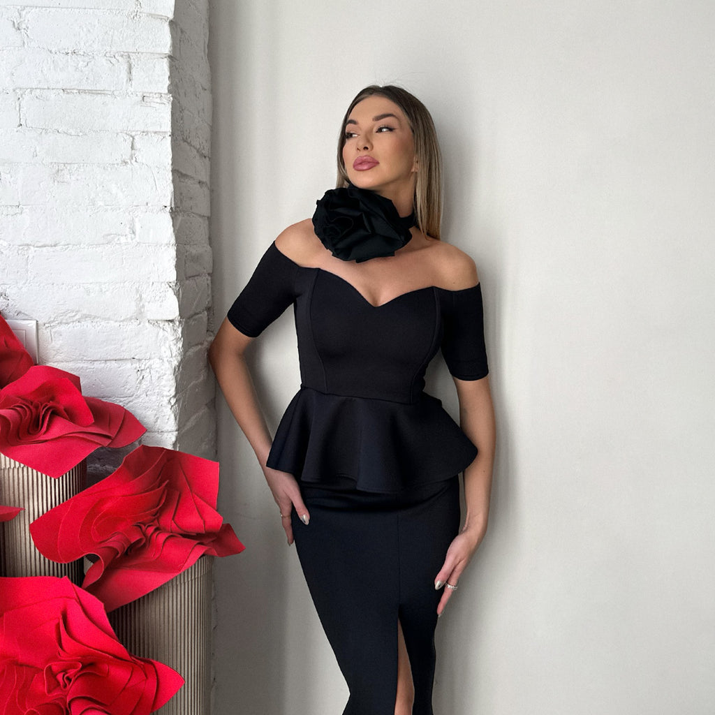 woman in black off shoulder dress standing near red decorations woman in black off shoulder dress standing near red decorations