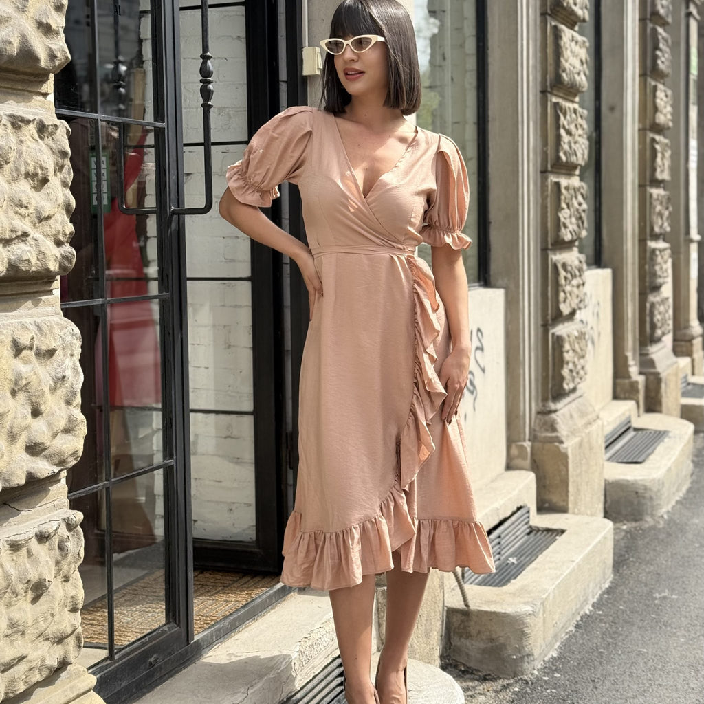 woman in peach wrap dress with urban background woman in peach wrap dress with urban background