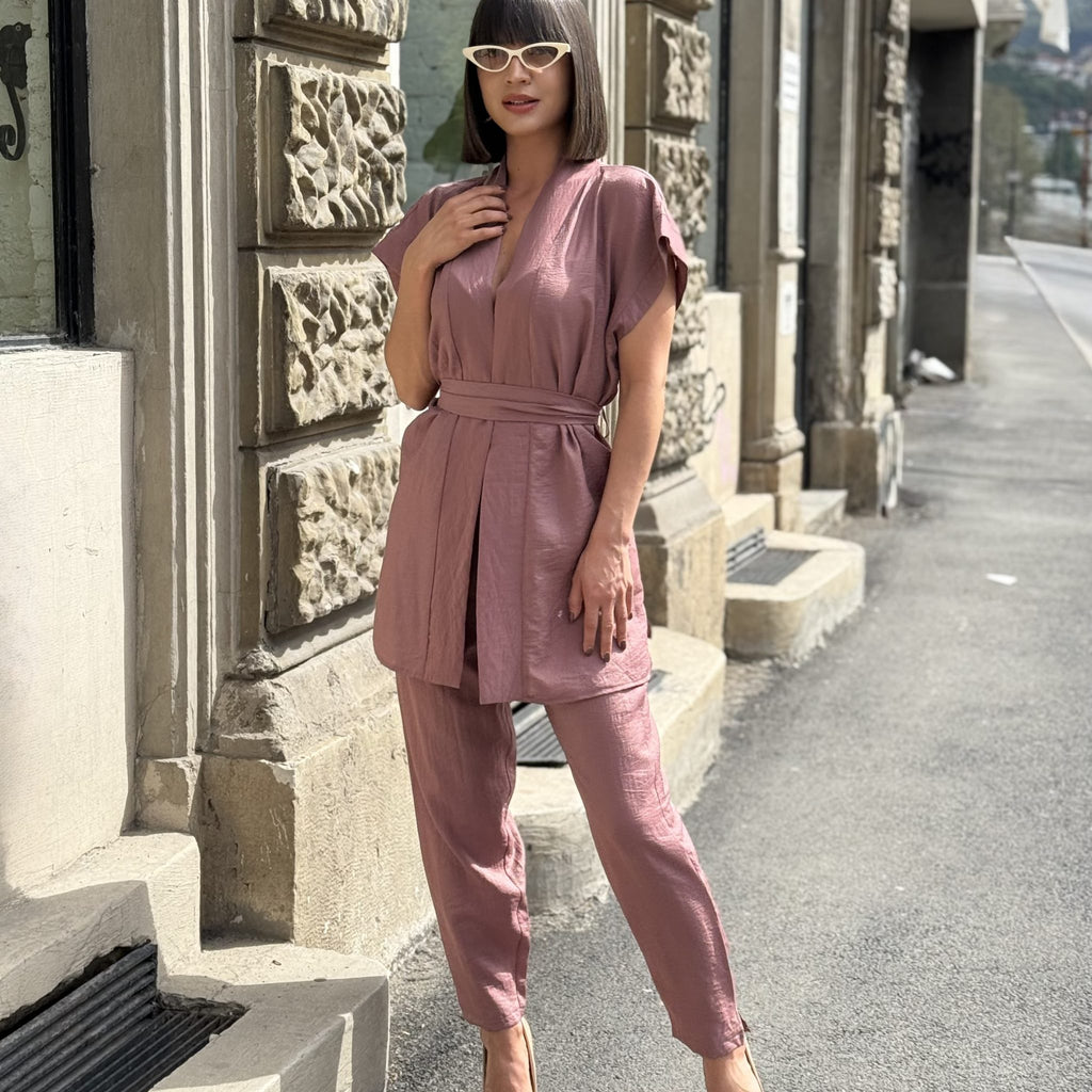woman in pink outfit standing on street woman in pink outfit standing on street