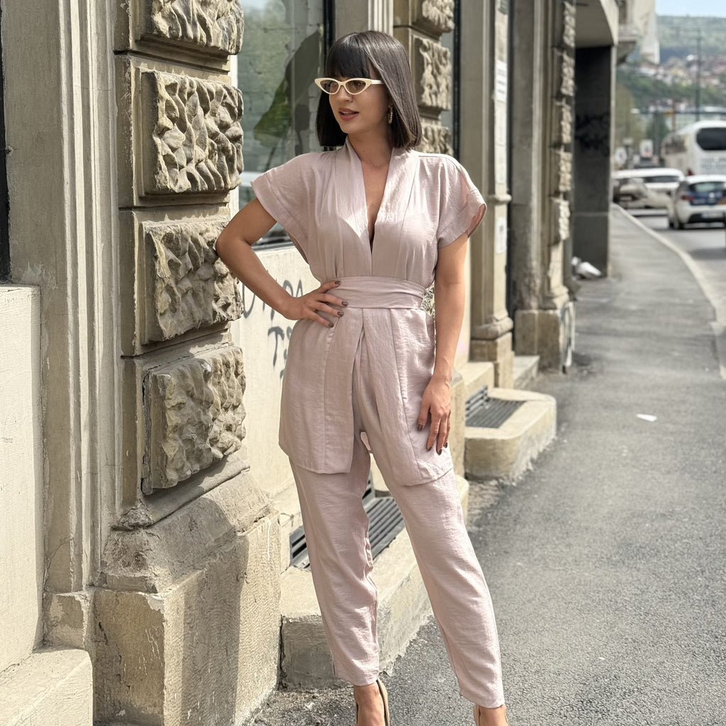 woman wearing pink jumpsuit with sunglasses in city street woman wearing pink jumpsuit with sunglasses in city street