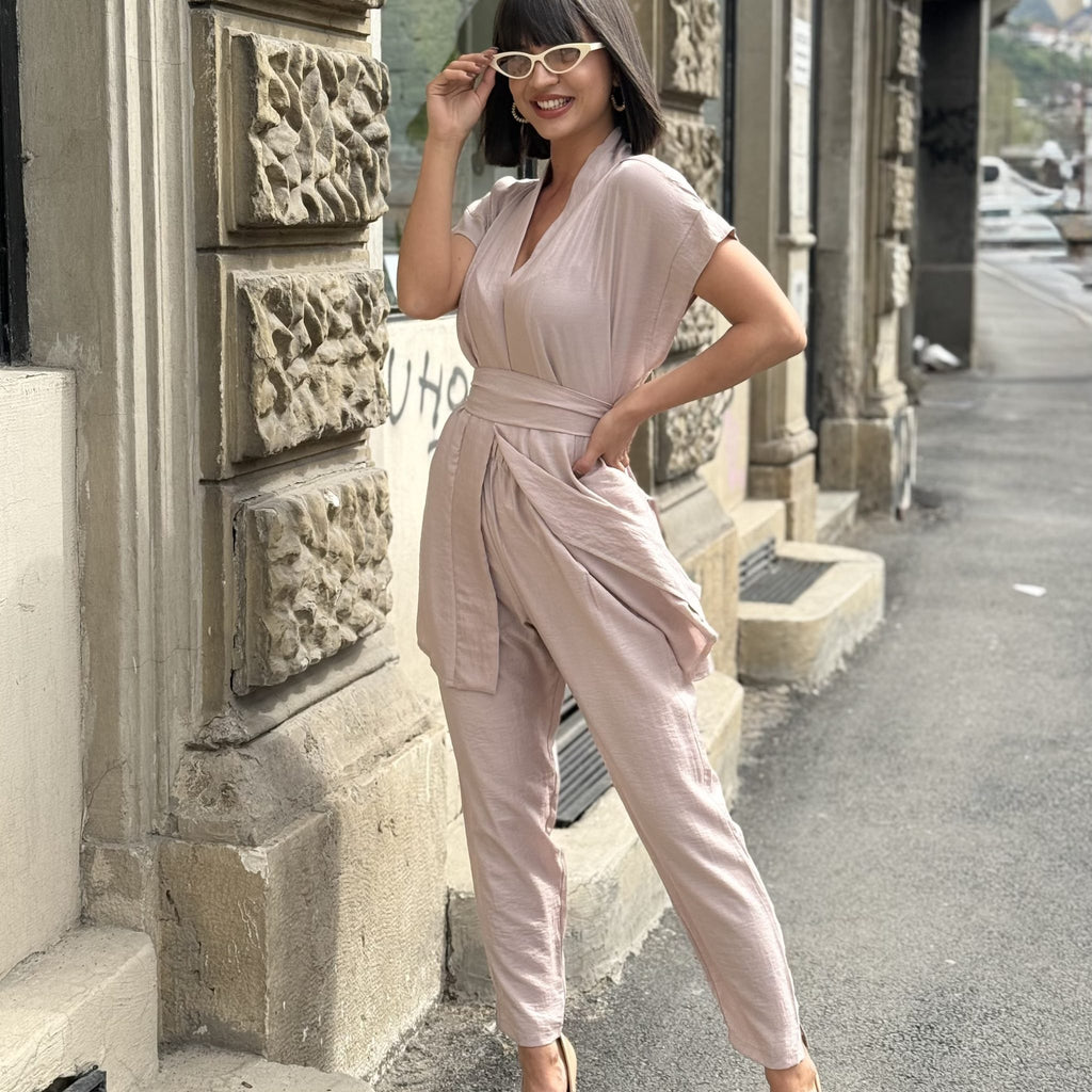 woman wearing light pink jumpsuit and beige heels on city street woman wearing light pink jumpsuit and beige heels on city street