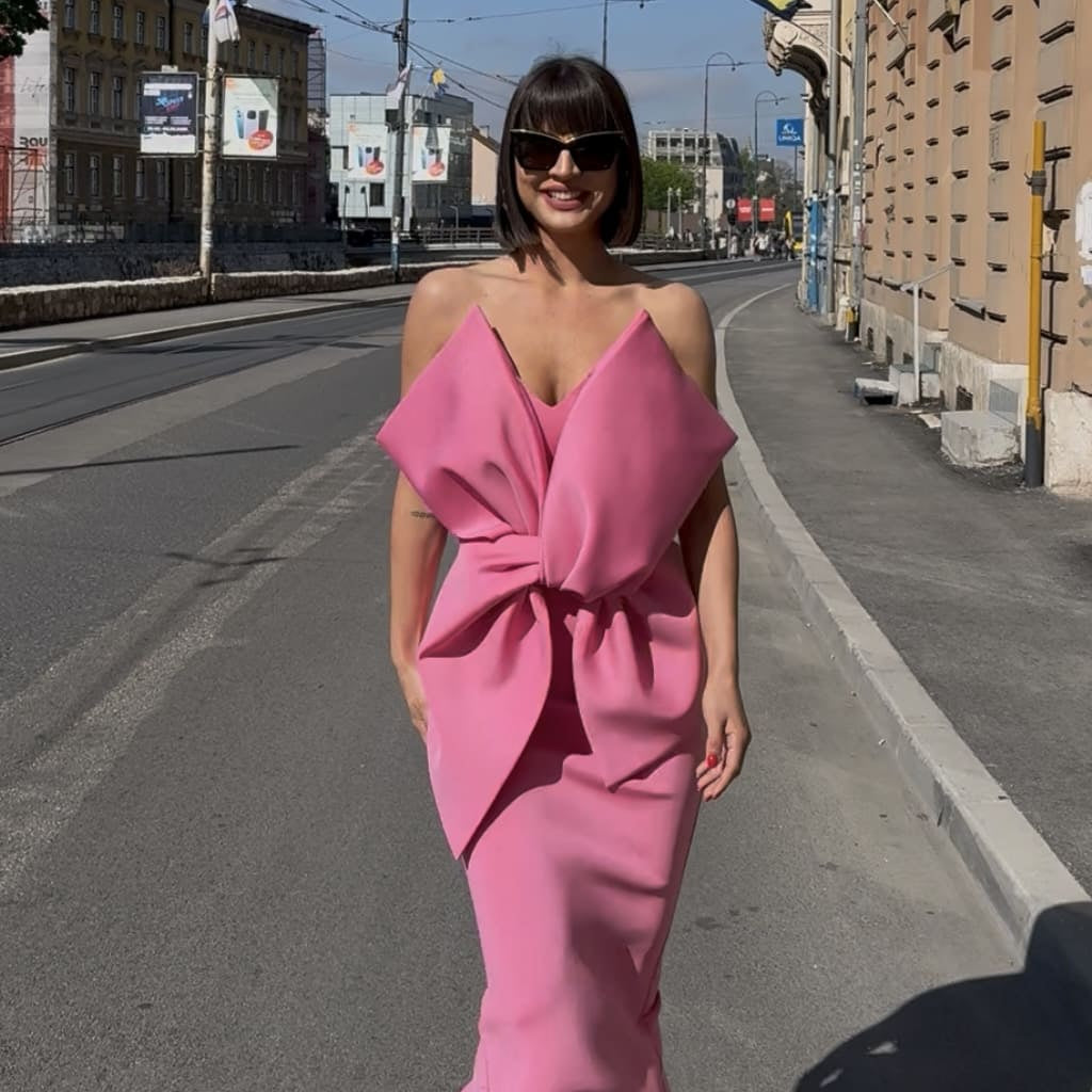 woman in pink bow dress on street woman in pink bow dress on street
