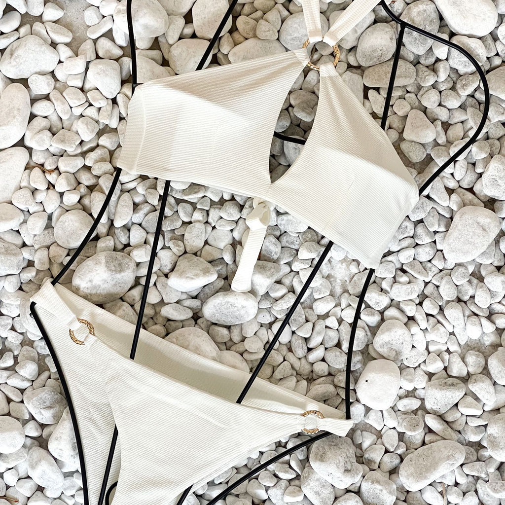 white bikini set on pebbles white bikini set on pebbles
