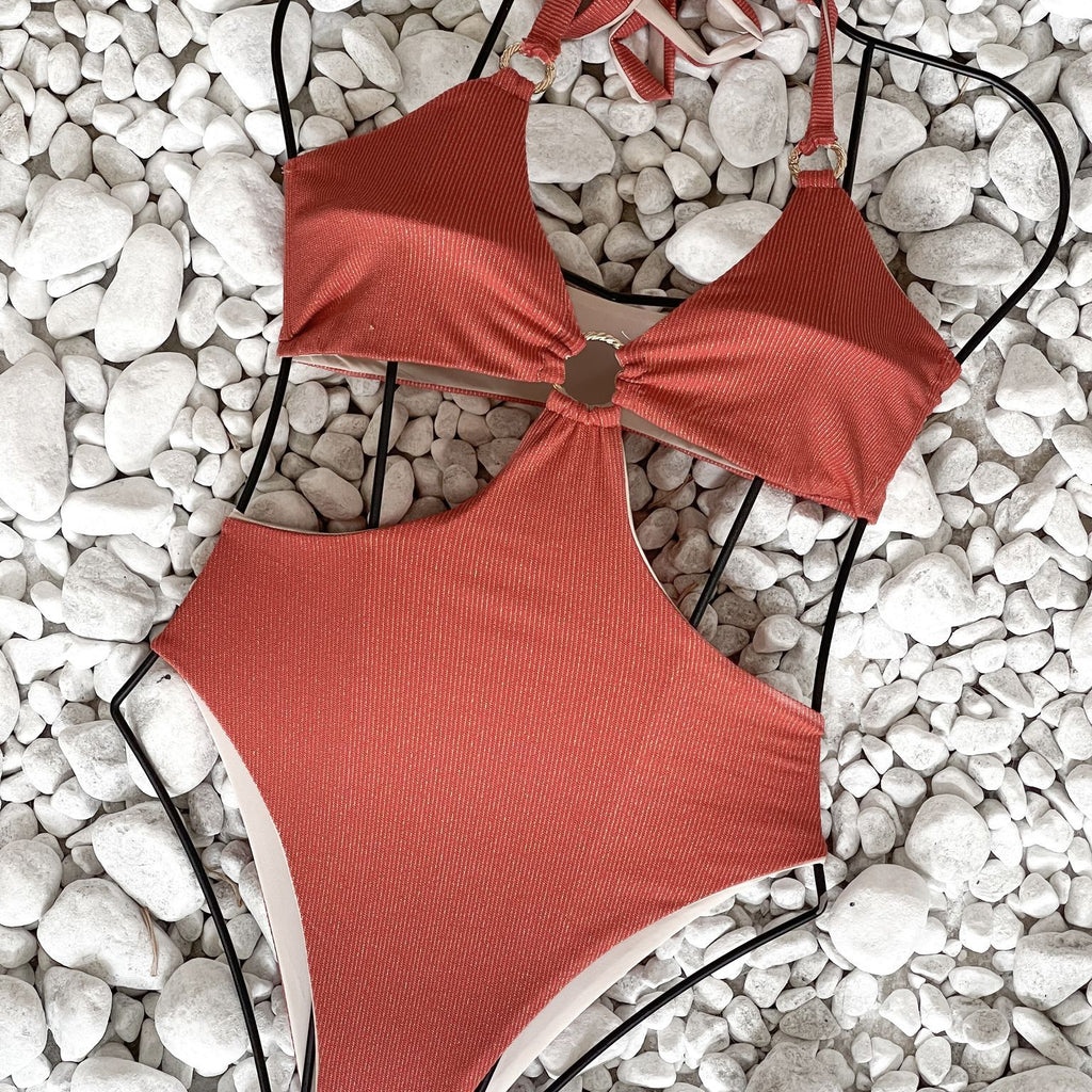 red one piece swimsuit on white pebbles red one piece swimsuit on white pebbles