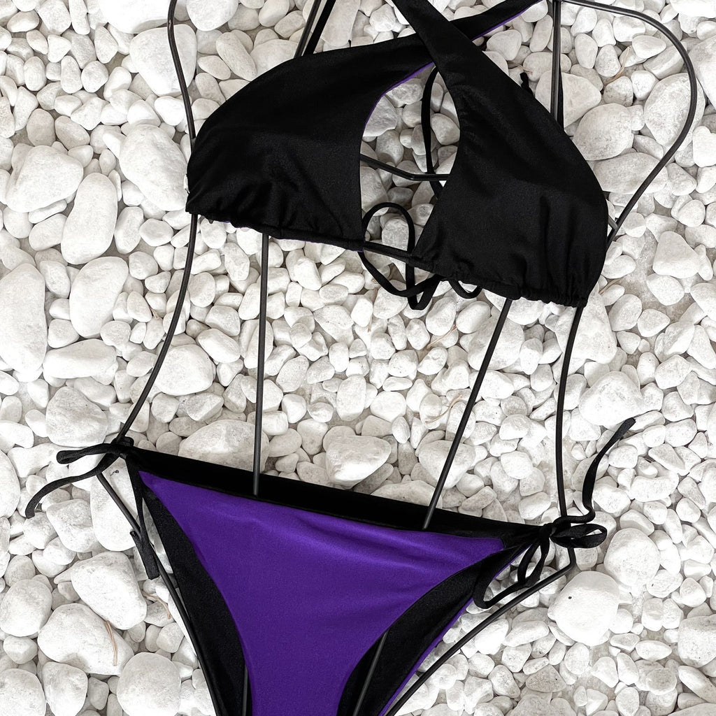 black and purple bikini on white pebbles black and purple bikini on white pebbles