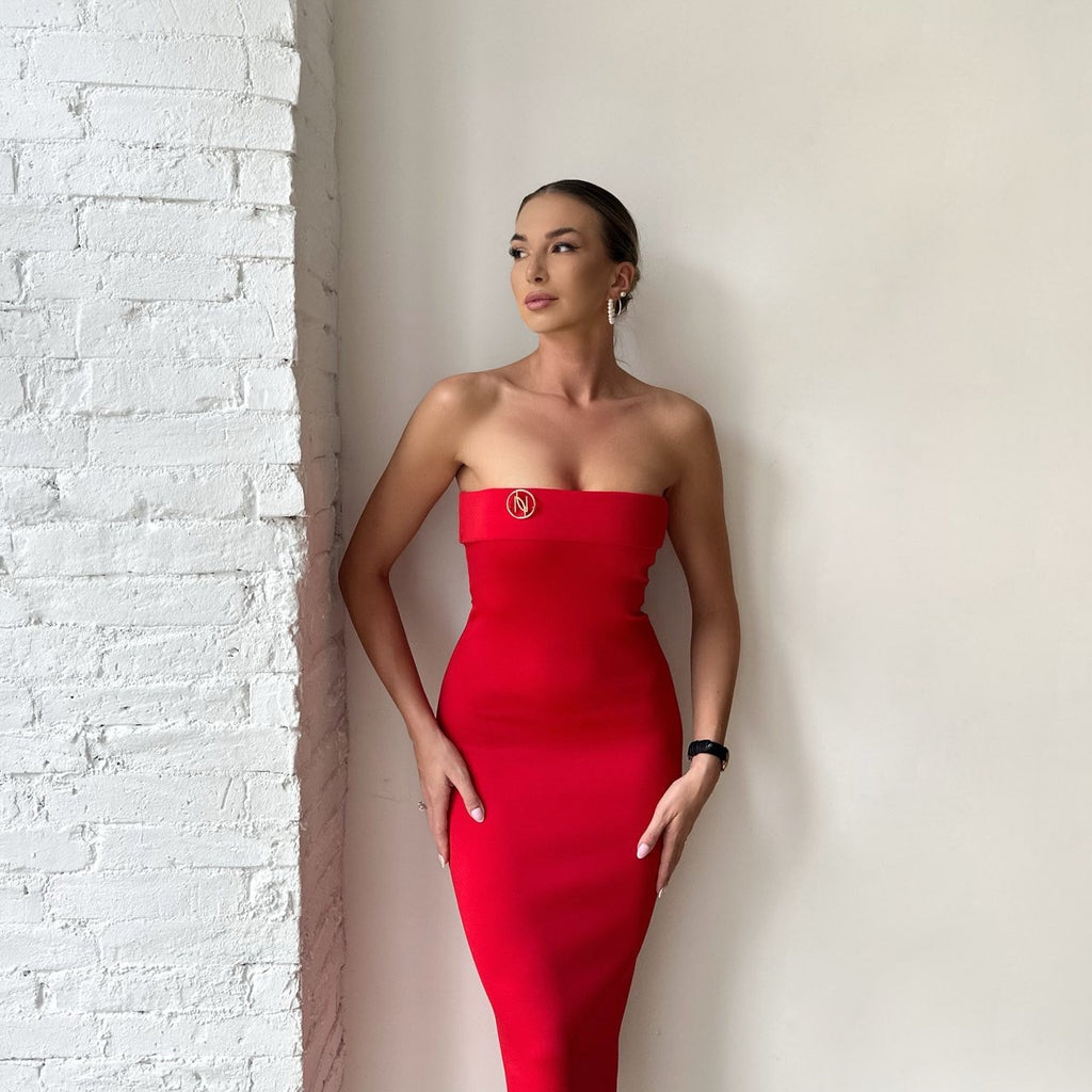 red strapless midi dress against white brick wall red strapless midi dress against white brick wall