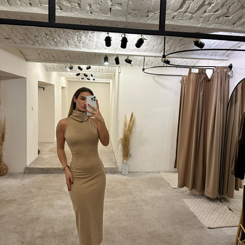 woman wearing beige sleeveless midi dress in dressing room woman wearing beige sleeveless midi dress in dressing room
