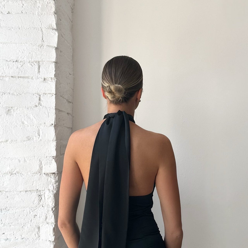 back view of woman in black halter dress back view of woman in black halter dress