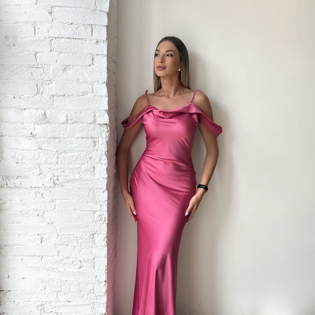 woman wearing pink satin gown standing near white wall woman wearing pink satin gown standing near white wall