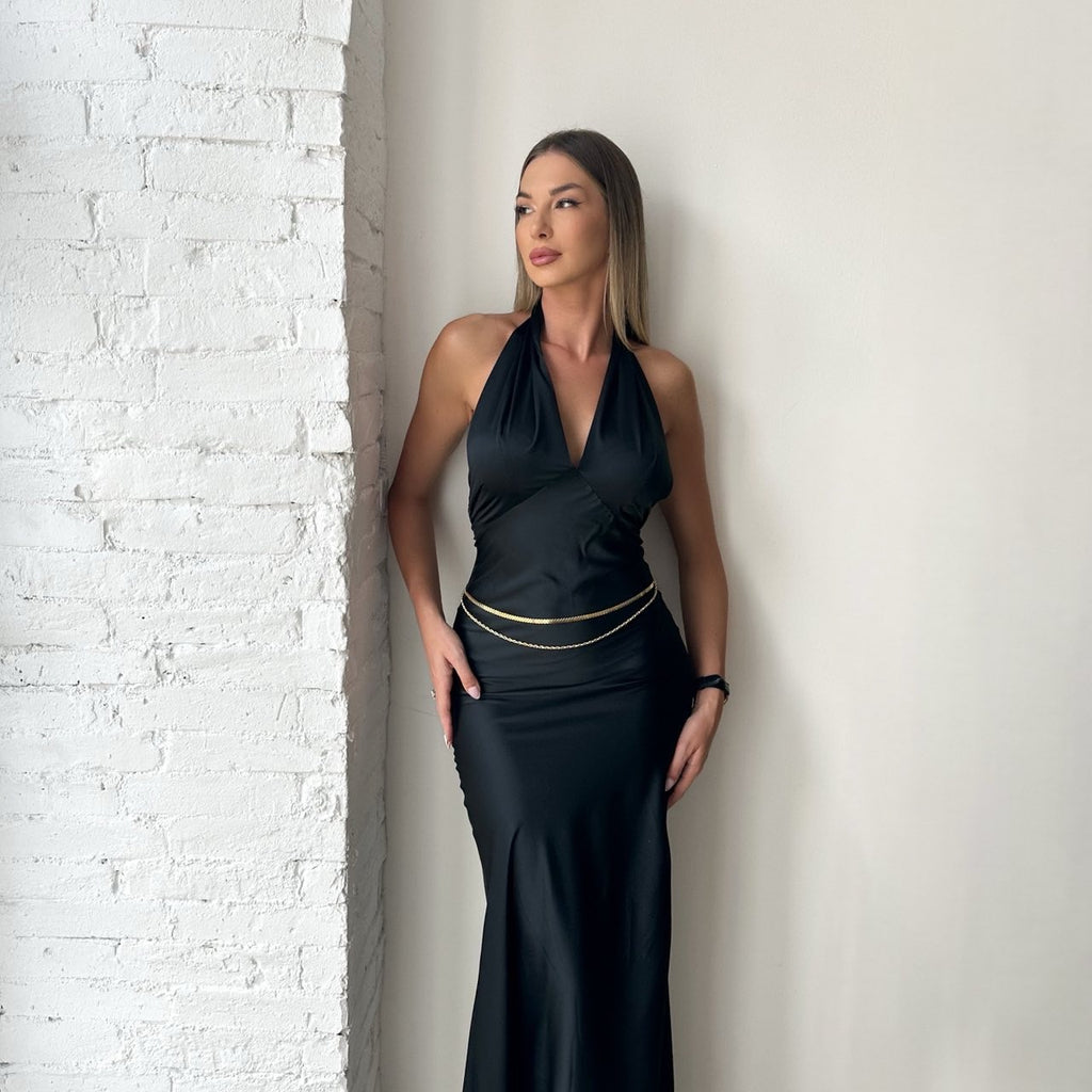 woman wearing black halter dress near white brick wall woman wearing black halter dress near white brick wall