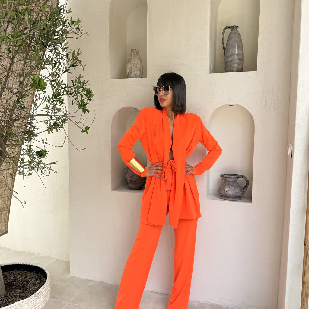 orange pantsuit on woman against neutral background orange pantsuit on woman against neutral background