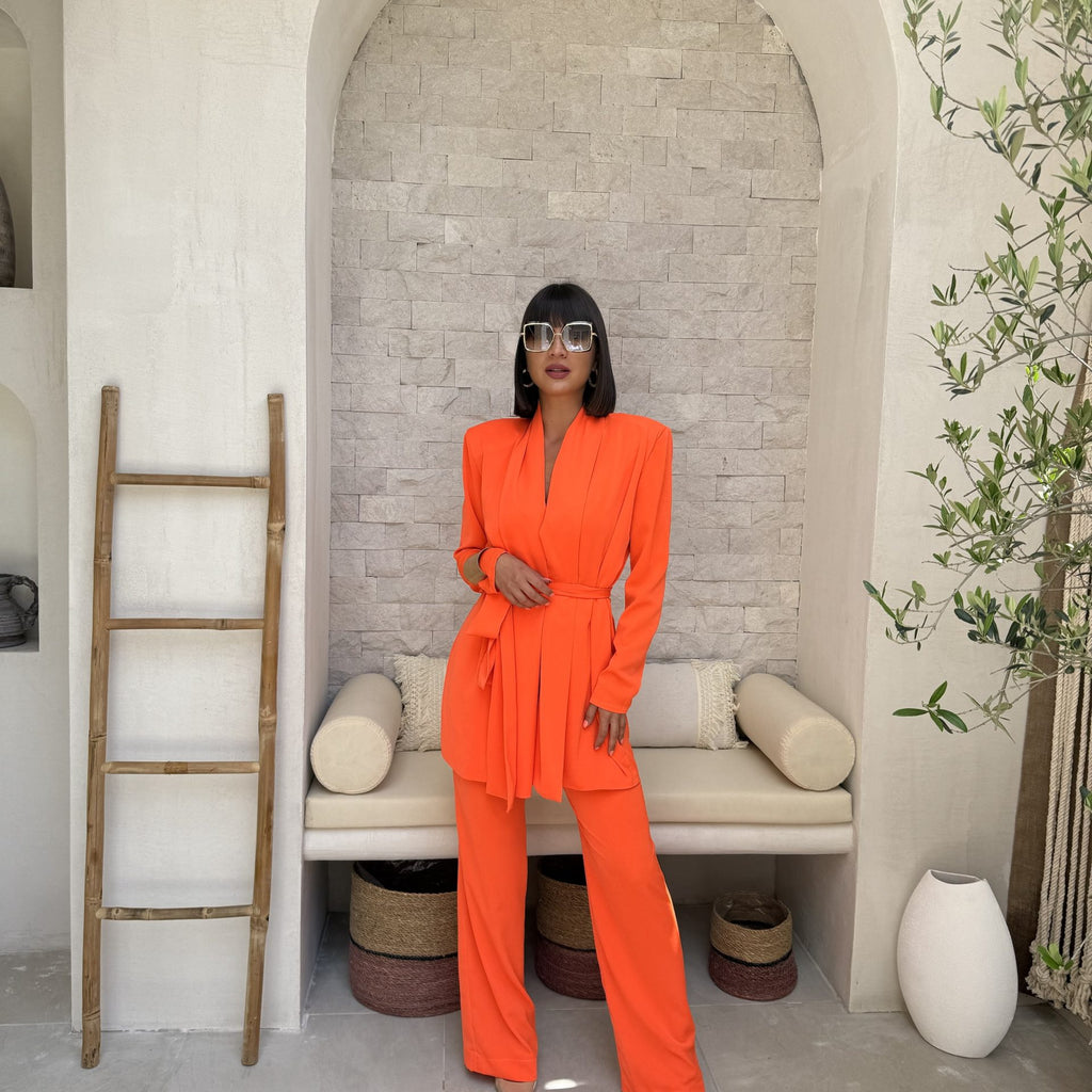 woman in orange pantsuit with sunglasses standing in arched niche woman in orange pantsuit with sunglasses standing in arched niche