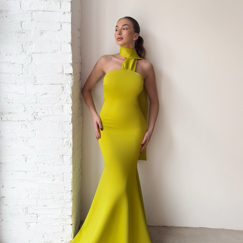 bright yellow halter neck evening gown against white brick wall bright yellow halter neck evening gown against white brick wall
