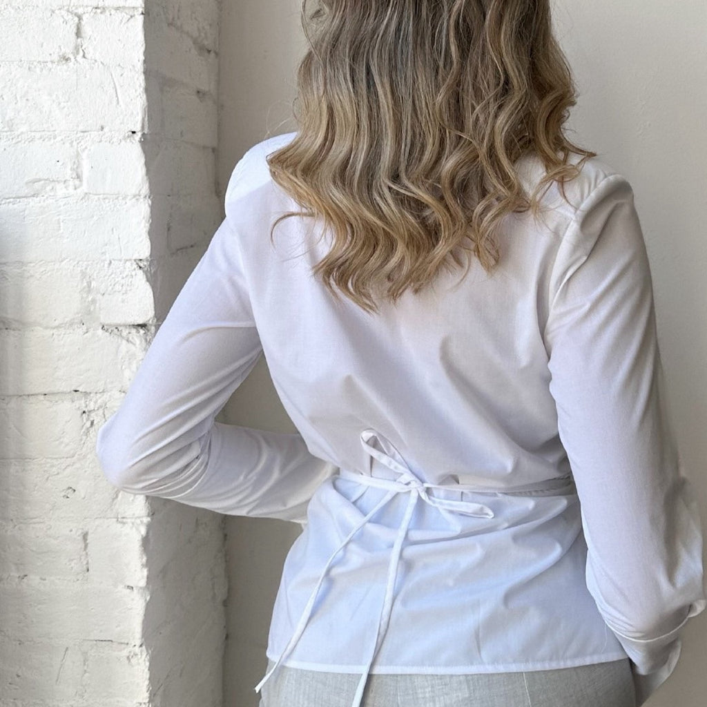 woman in white long sleeve blouse with back tie woman in white long sleeve blouse with back tie
