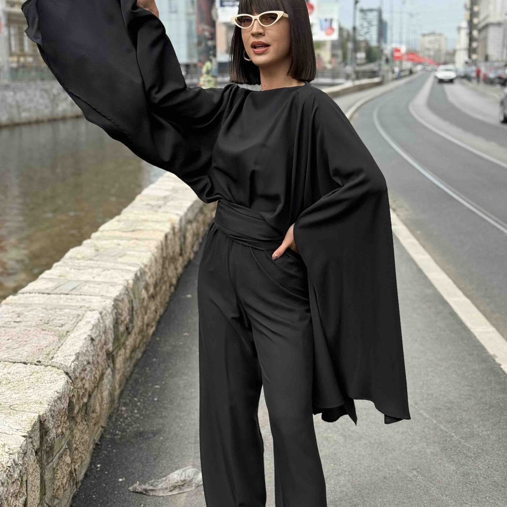fashion woman in black flowy outfit near urban canal fashion woman in black flowy outfit near urban canal