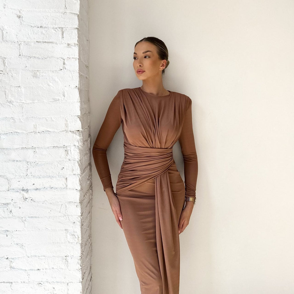 sleeveless brown ruched midi dress against white brick wall sleeveless brown ruched midi dress against white brick wall