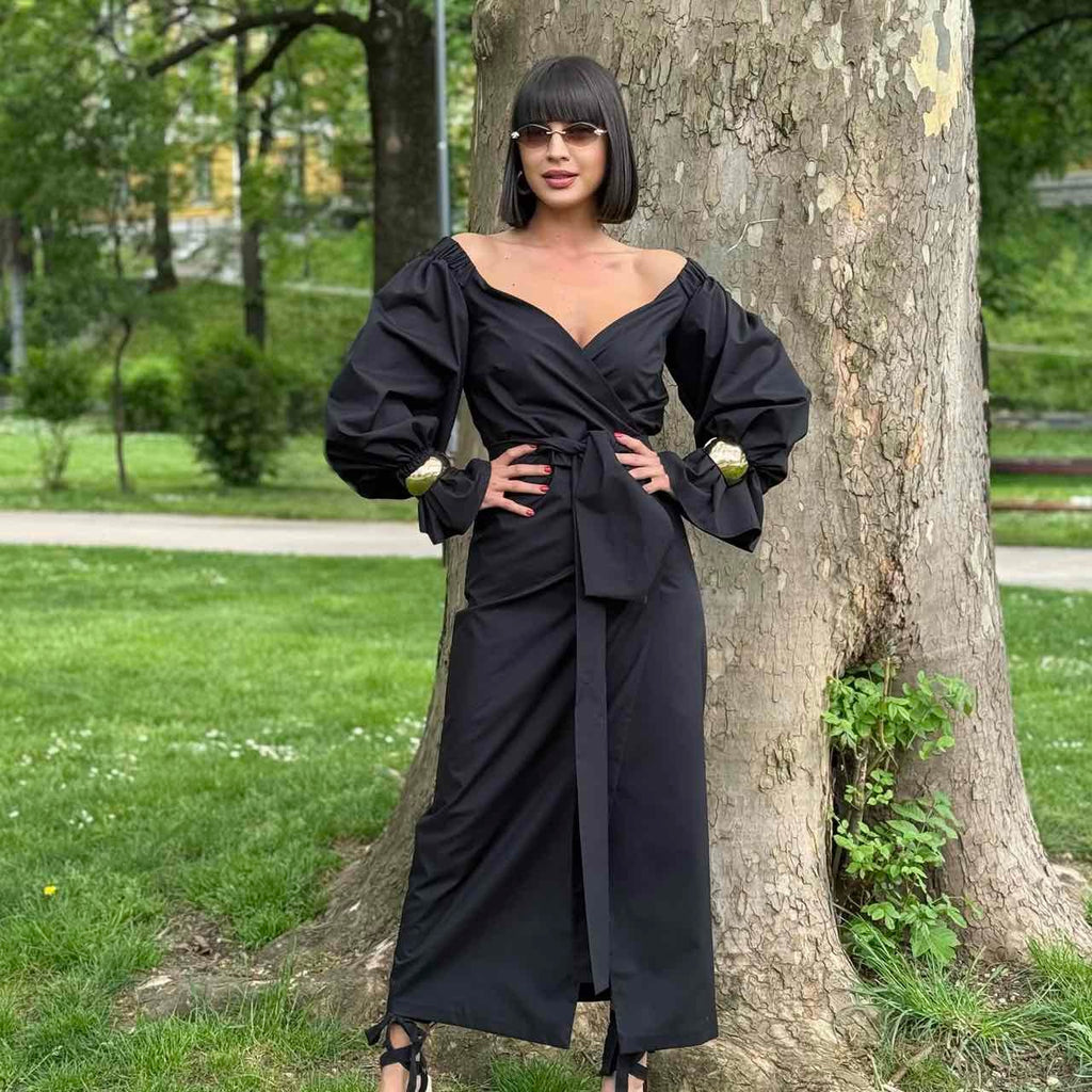 woman in black long sleeve wrap dress near tree woman in black long sleeve wrap dress near tree