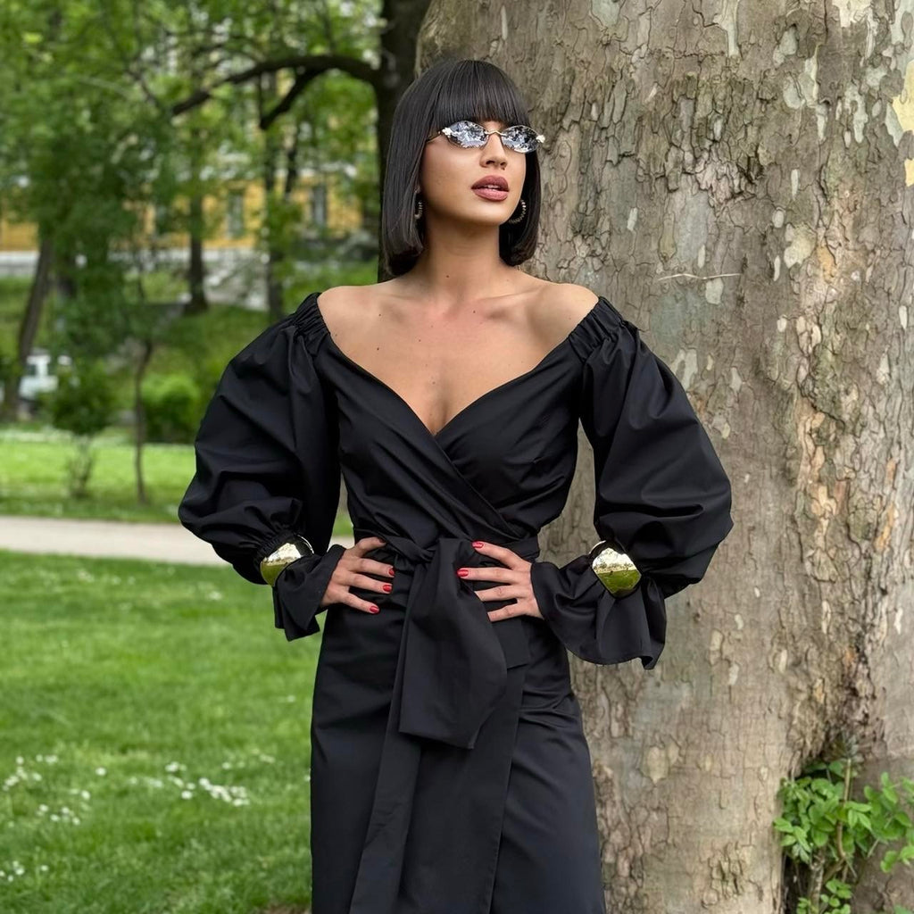 woman in black off shoulder dress standing by tree woman in black off shoulder dress standing by tree