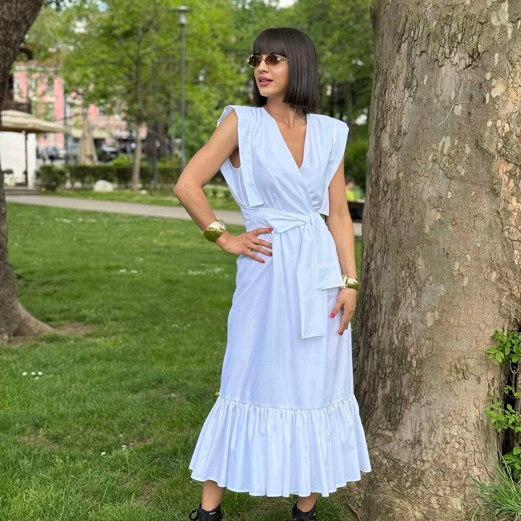 woman in sleeveless white midi dress standing outdoors woman in sleeveless white midi dress standing outdoors