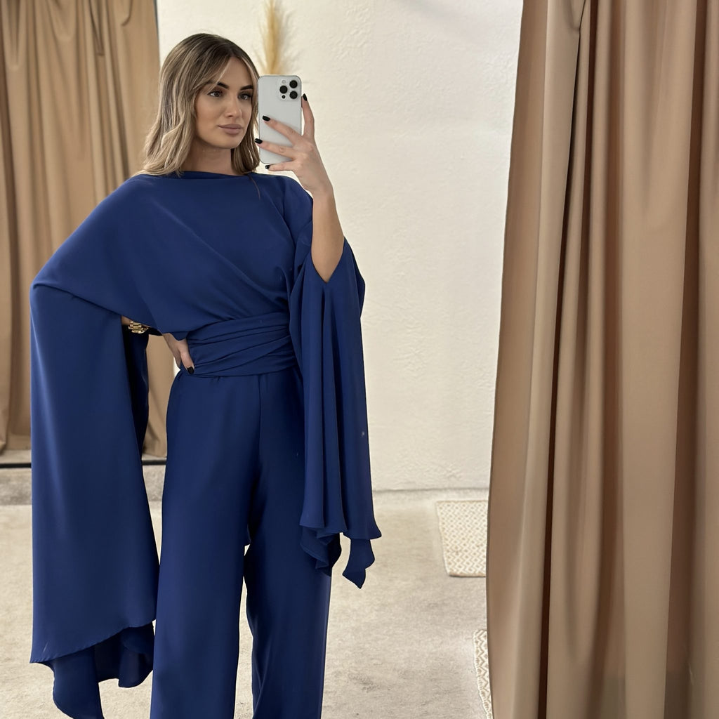 woman wearing navy blue elegant jumpsuit in dressing room woman wearing navy blue elegant jumpsuit in dressing room