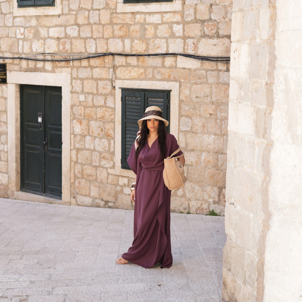 woman in purple maxi dress and straw hat woman in purple maxi dress and straw hat