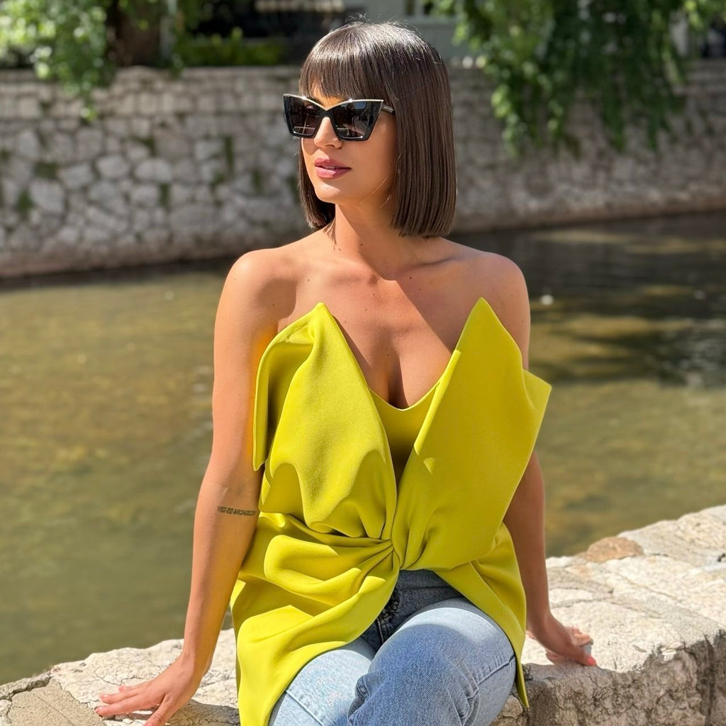 woman wearing yellow top and jeans near water woman wearing yellow top and jeans near water