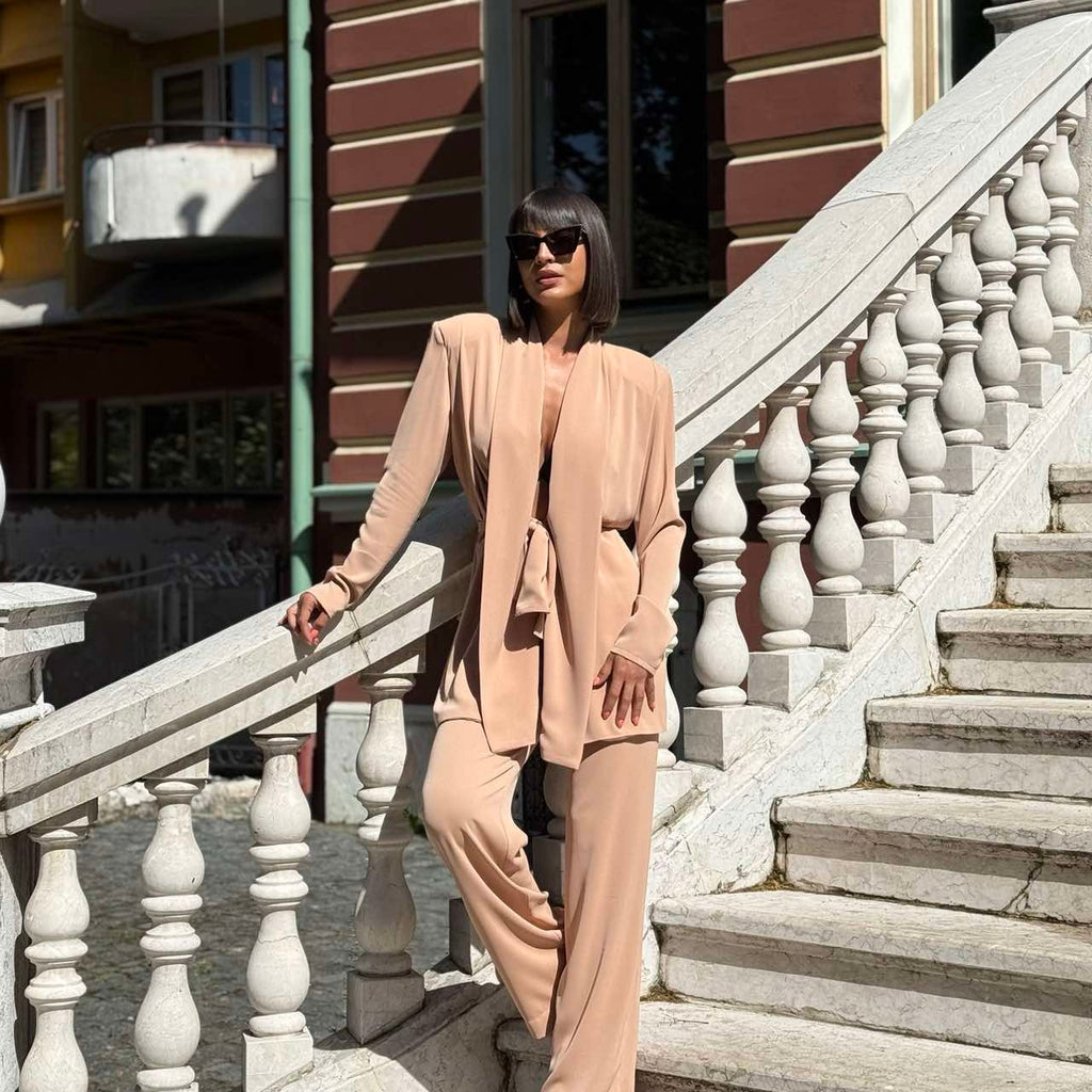 woman wearing beige pantsuit on marble stairs woman wearing beige pantsuit on marble stairs