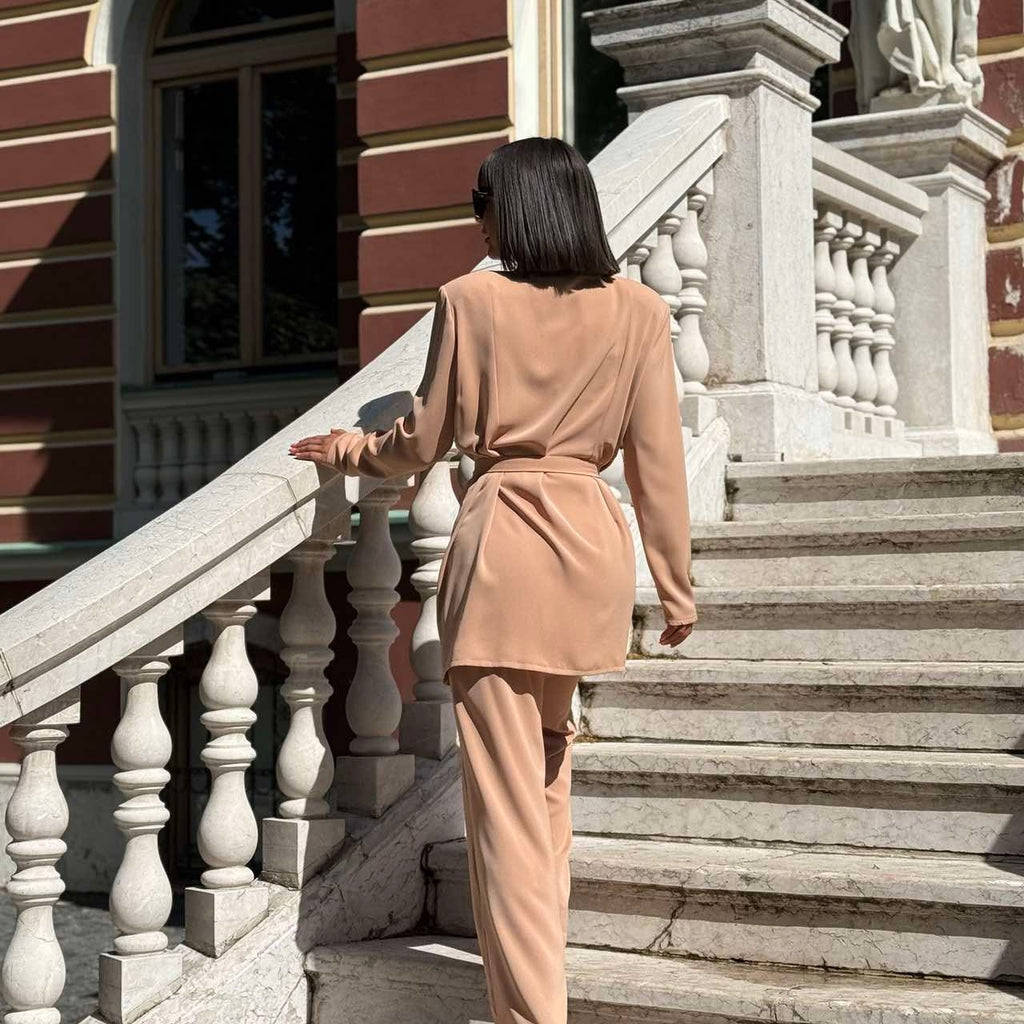woman in beige outfit walking up stairs woman in beige outfit walking up stairs