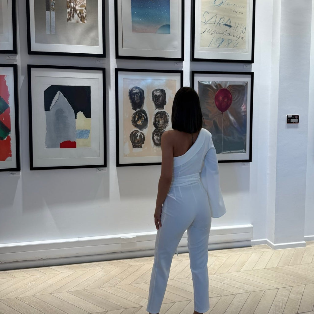 woman in white jumpsuit viewing art gallery woman in white jumpsuit viewing art gallery