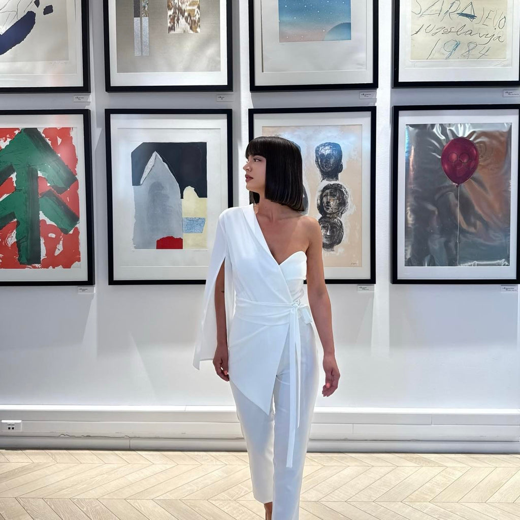 woman in elegant white one sleeve dress in art gallery woman in elegant white one sleeve dress in art gallery