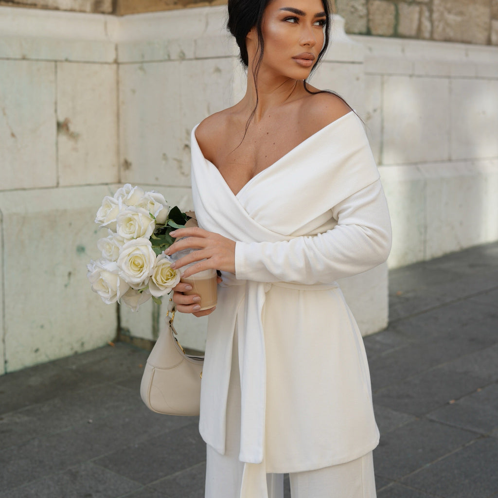 woman wearing off shoulder white dress holding roses and handbag woman wearing off shoulder white dress holding roses and handbag