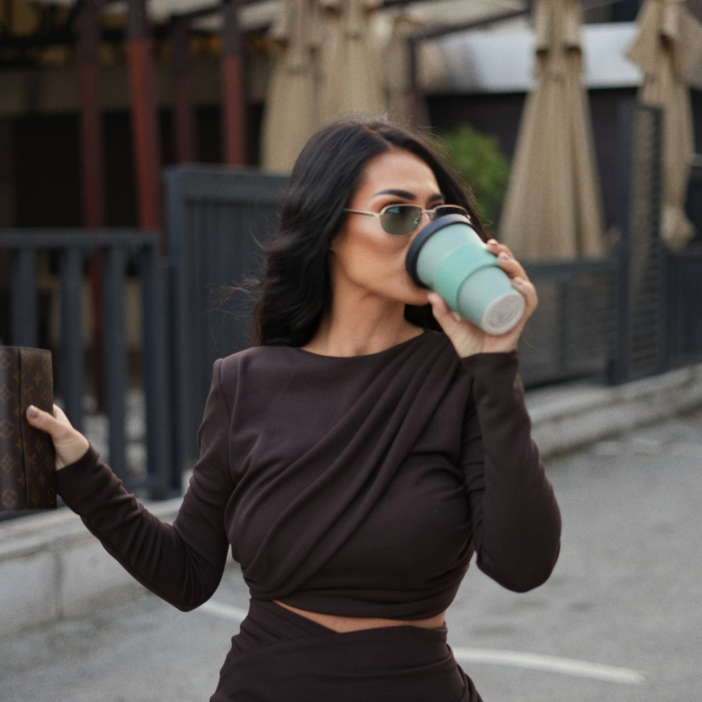 woman wearing elegant brown dress and sunglasses drinking coffee woman wearing elegant brown dress and sunglasses drinking coffee