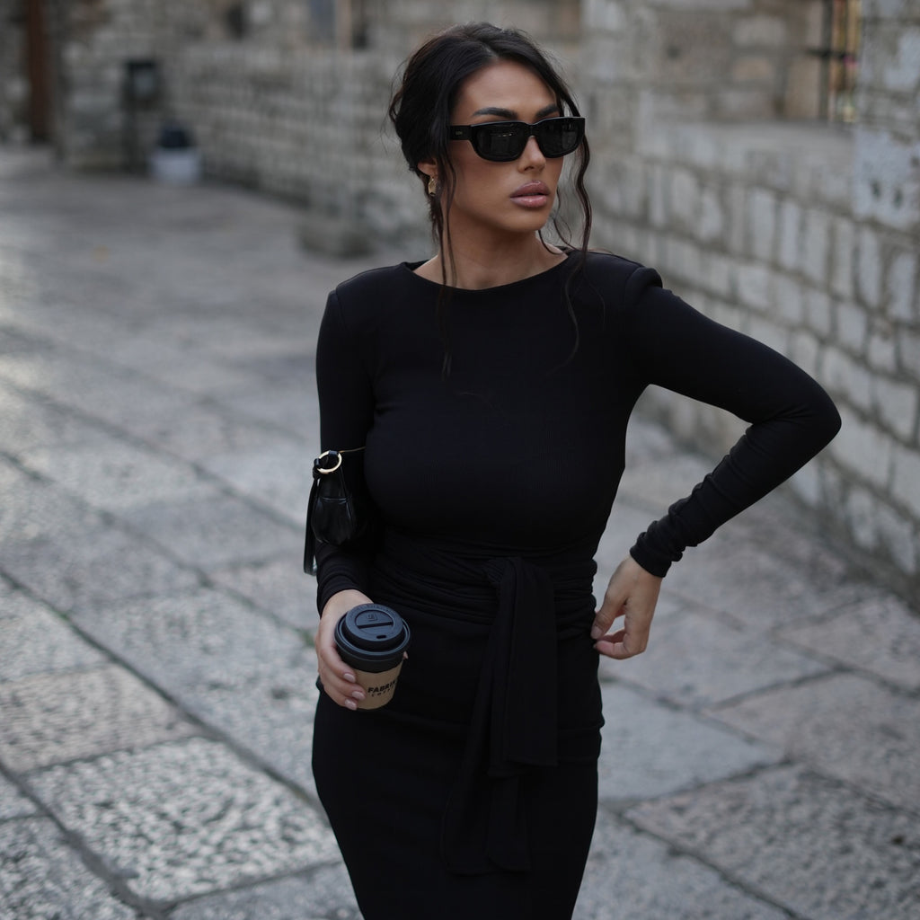 woman wearing black dress and sunglasses holding coffee cup woman wearing black dress and sunglasses holding coffee cup