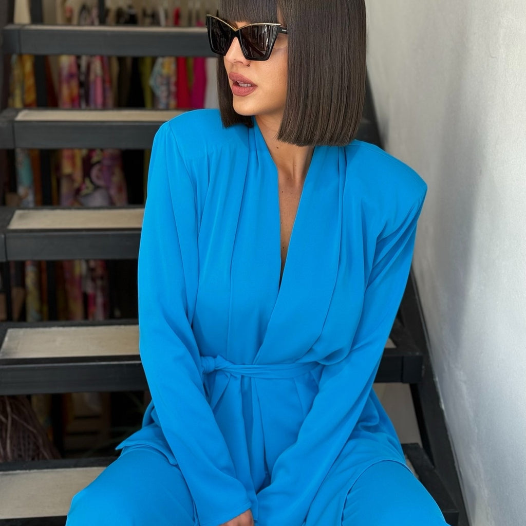 woman in blue wrap dress sitting on stairs woman in blue wrap dress sitting on stairs