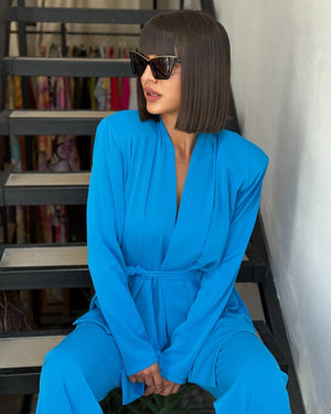 woman in blue wrap dress sitting on stairs woman in blue wrap dress sitting on stairs