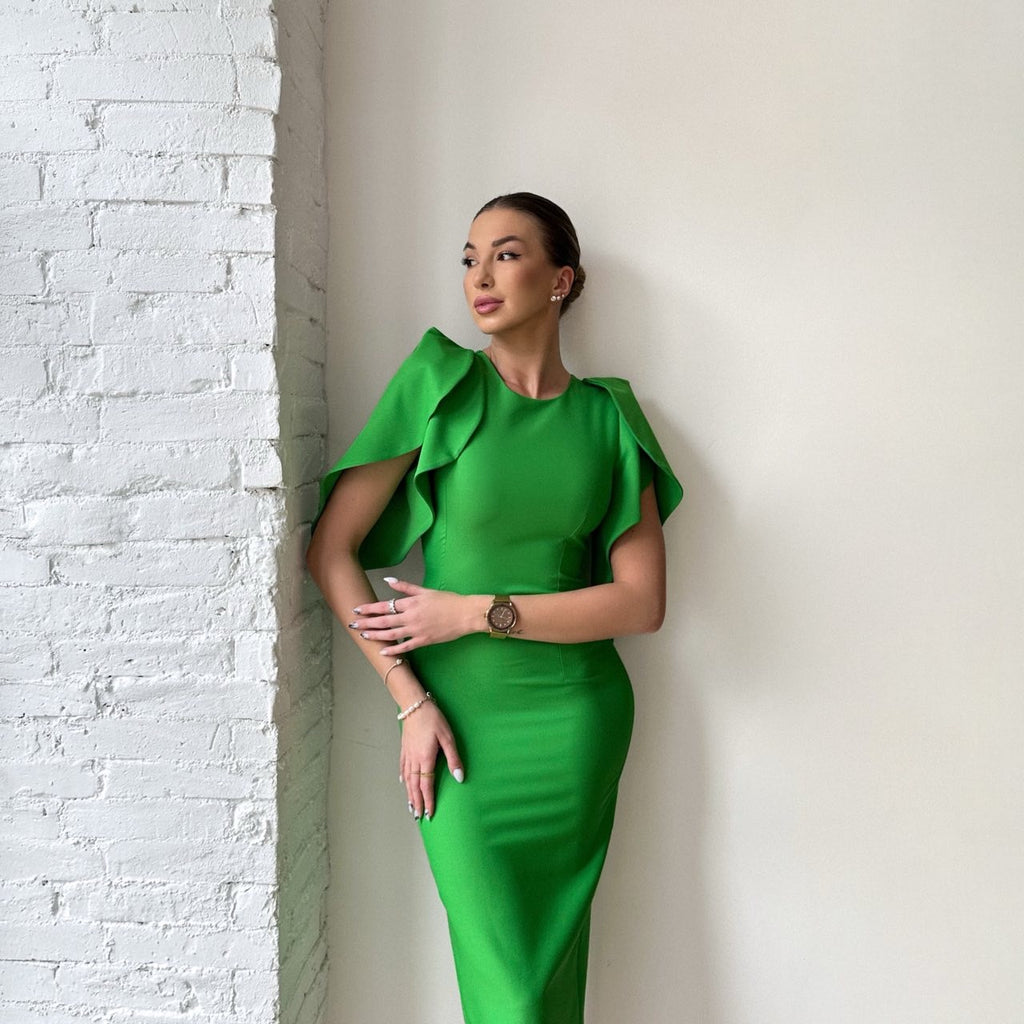 woman in green sleeve ruffle dress standing indoors woman in green sleeve ruffle dress standing indoors