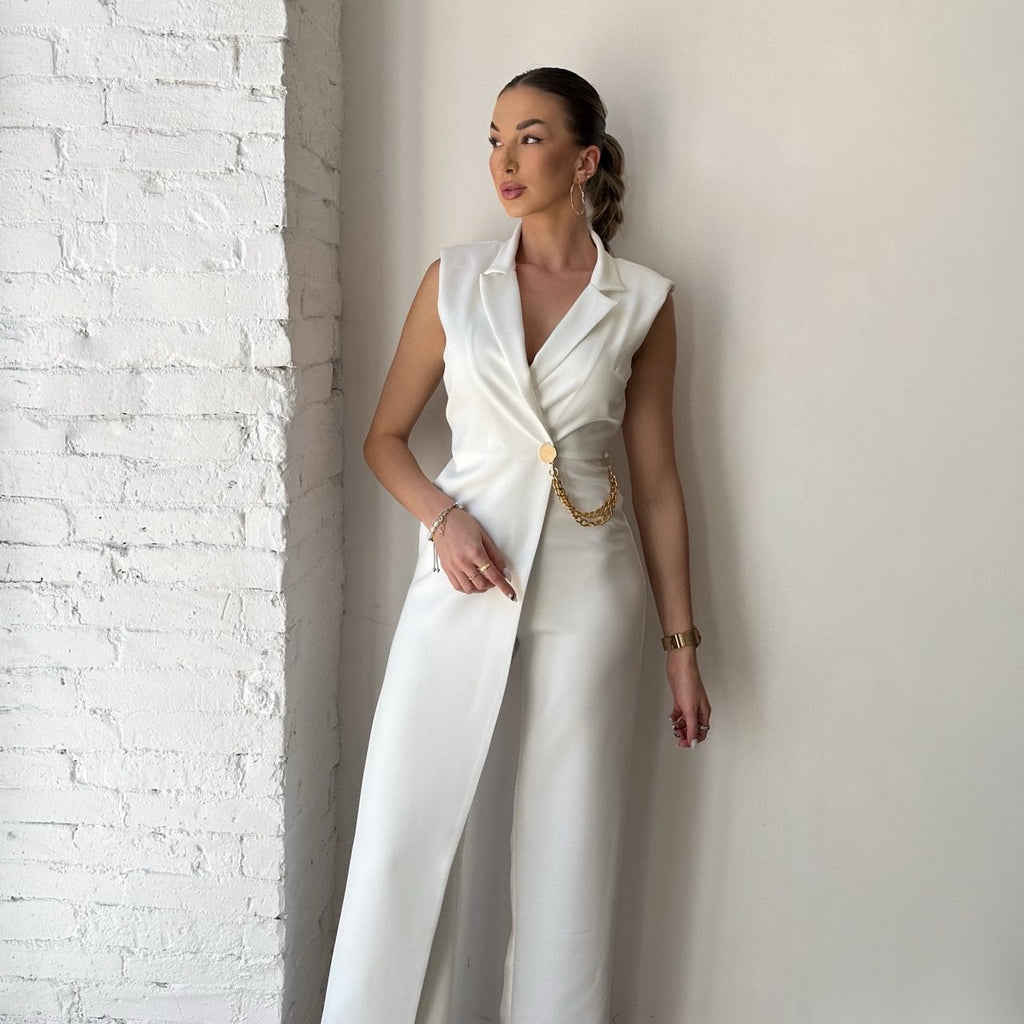 woman in white sleeveless long tailored outfit with chain detail woman in white sleeveless long tailored outfit with chain detail