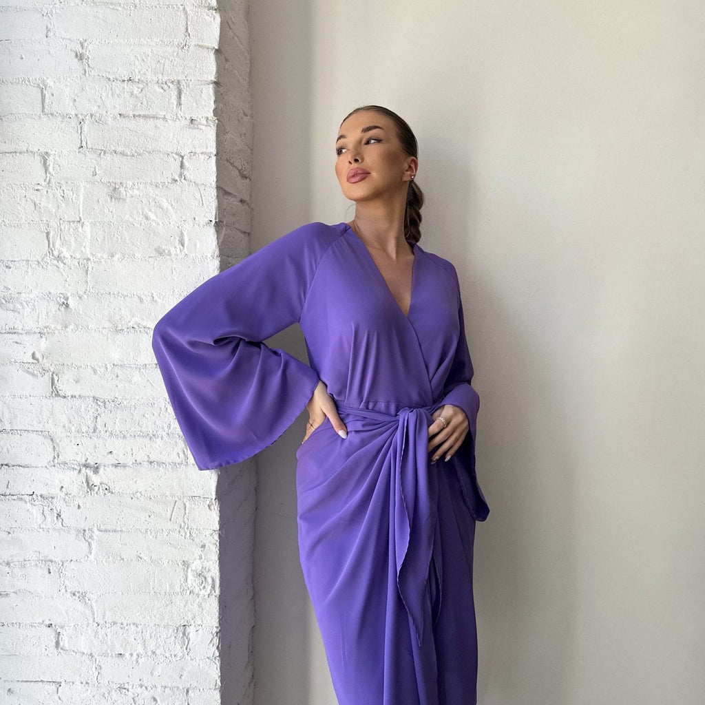 woman in purple wrap dress with bell sleeves woman in purple wrap dress with bell sleeves