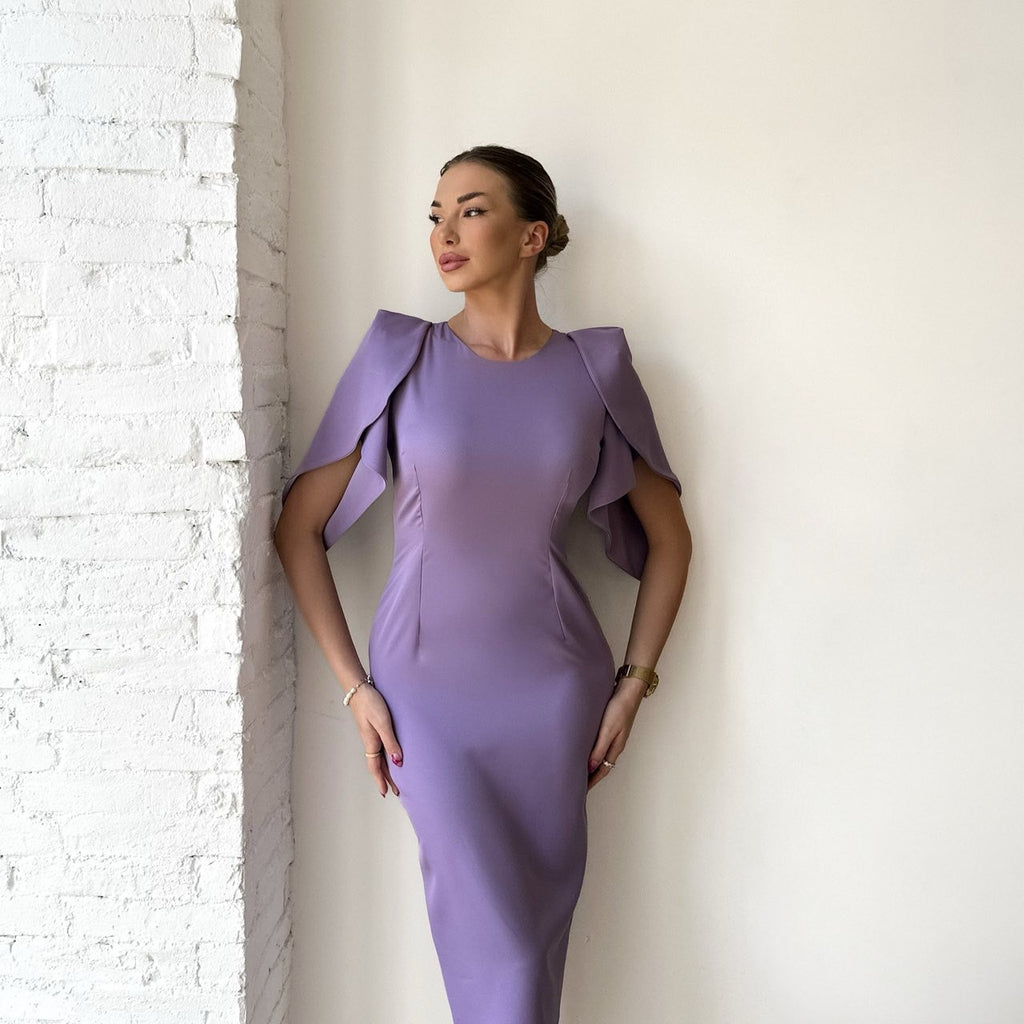 woman in elegant lavender dress posed against white wall woman in elegant lavender dress posed against white wall