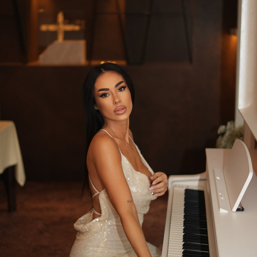 woman in sparkling white dress sitting at piano woman in sparkling white dress sitting at piano