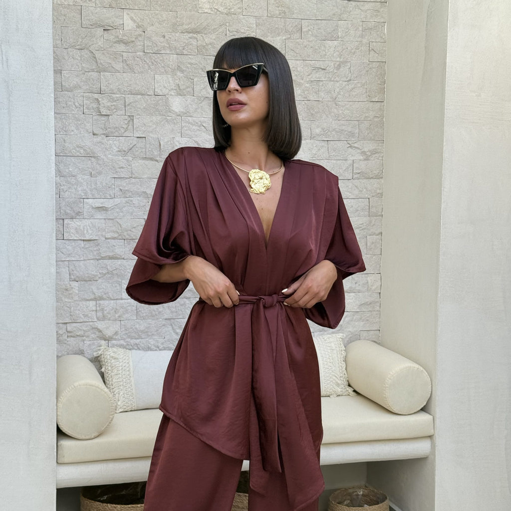 brunette woman in burgundy wrap dress with sunglasses indoors brunette woman in burgundy wrap dress with sunglasses indoors