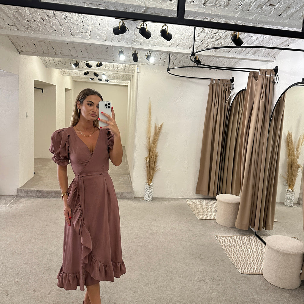 woman wearing ruffled brown dress in modern boutique fitting room woman wearing ruffled brown dress in modern boutique fitting room
