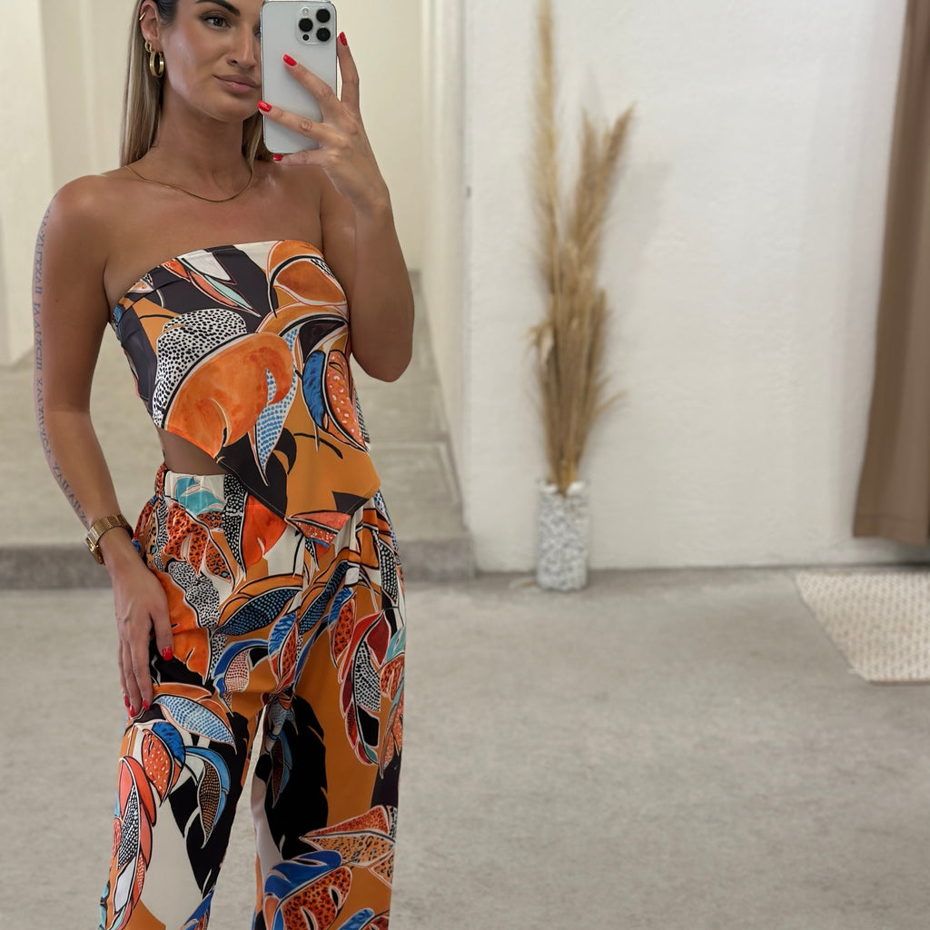 woman wearing colorful strapless jumpsuit taking selfie woman wearing colorful strapless jumpsuit taking selfie