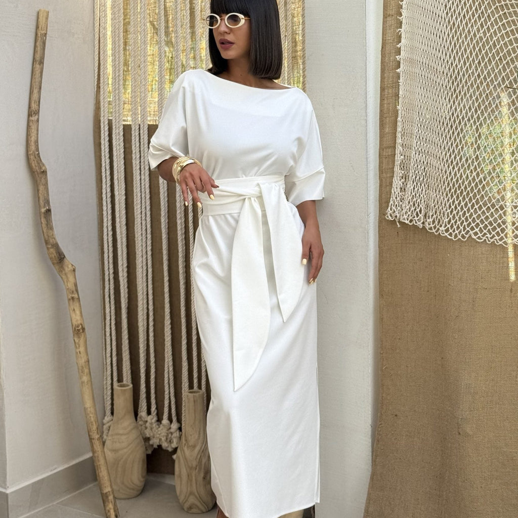a woman wearing an elegant white maxi dress with sunglasses at home a woman wearing an elegant white maxi dress with sunglasses at home