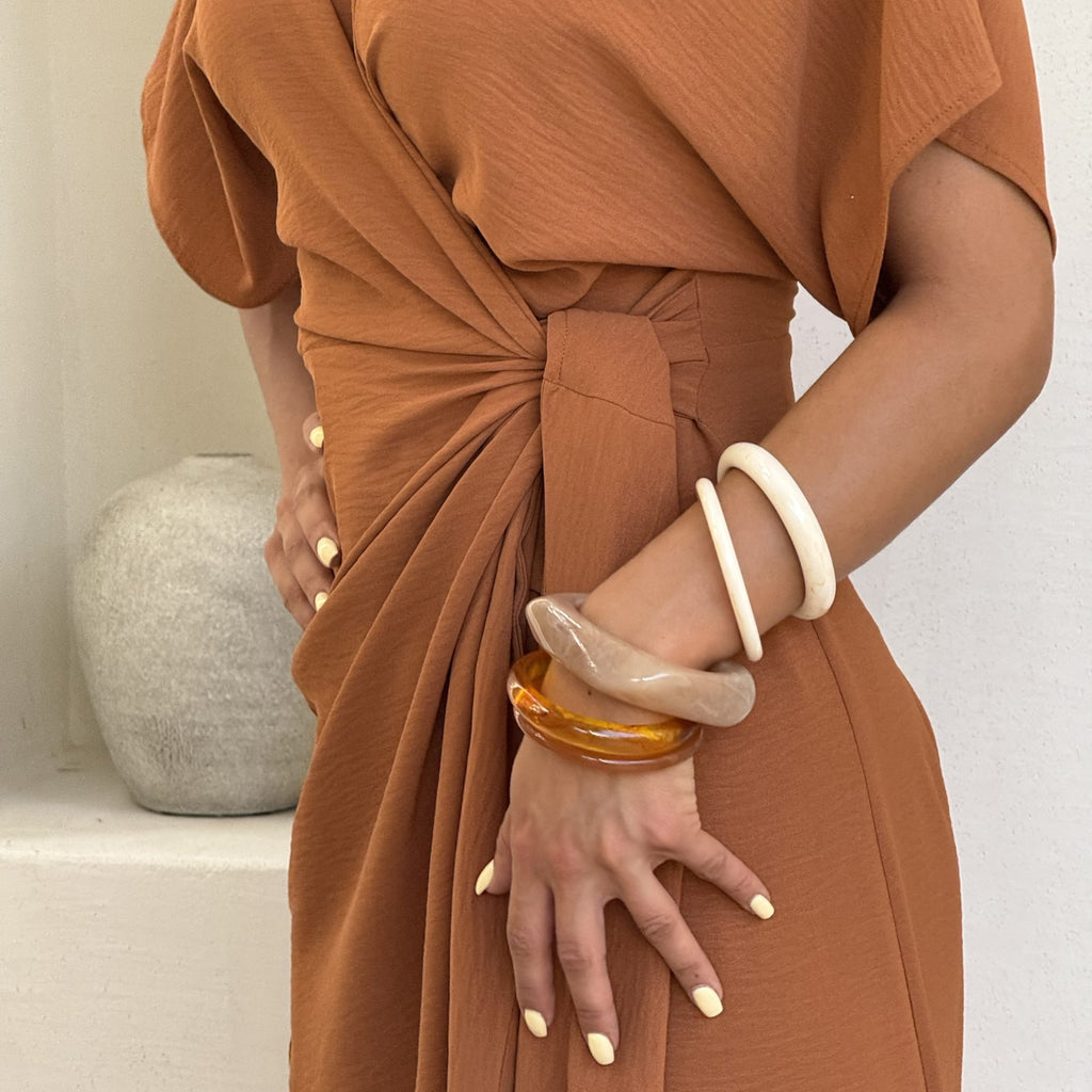 rust colored dress with draped design and bracelets rust colored dress with draped design and bracelets
