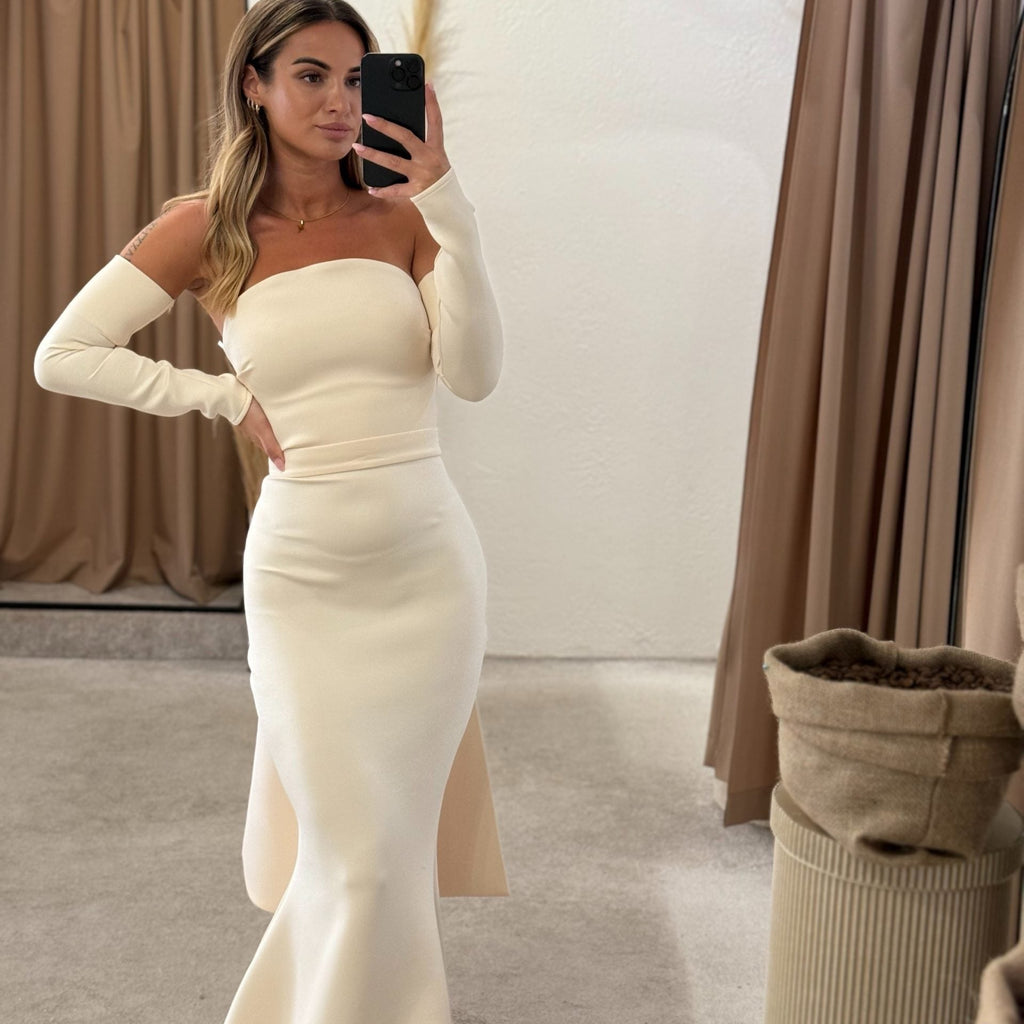 woman wearing elegant off shoulder white mermaid dress in fitting room woman wearing elegant off shoulder white mermaid dress in fitting room