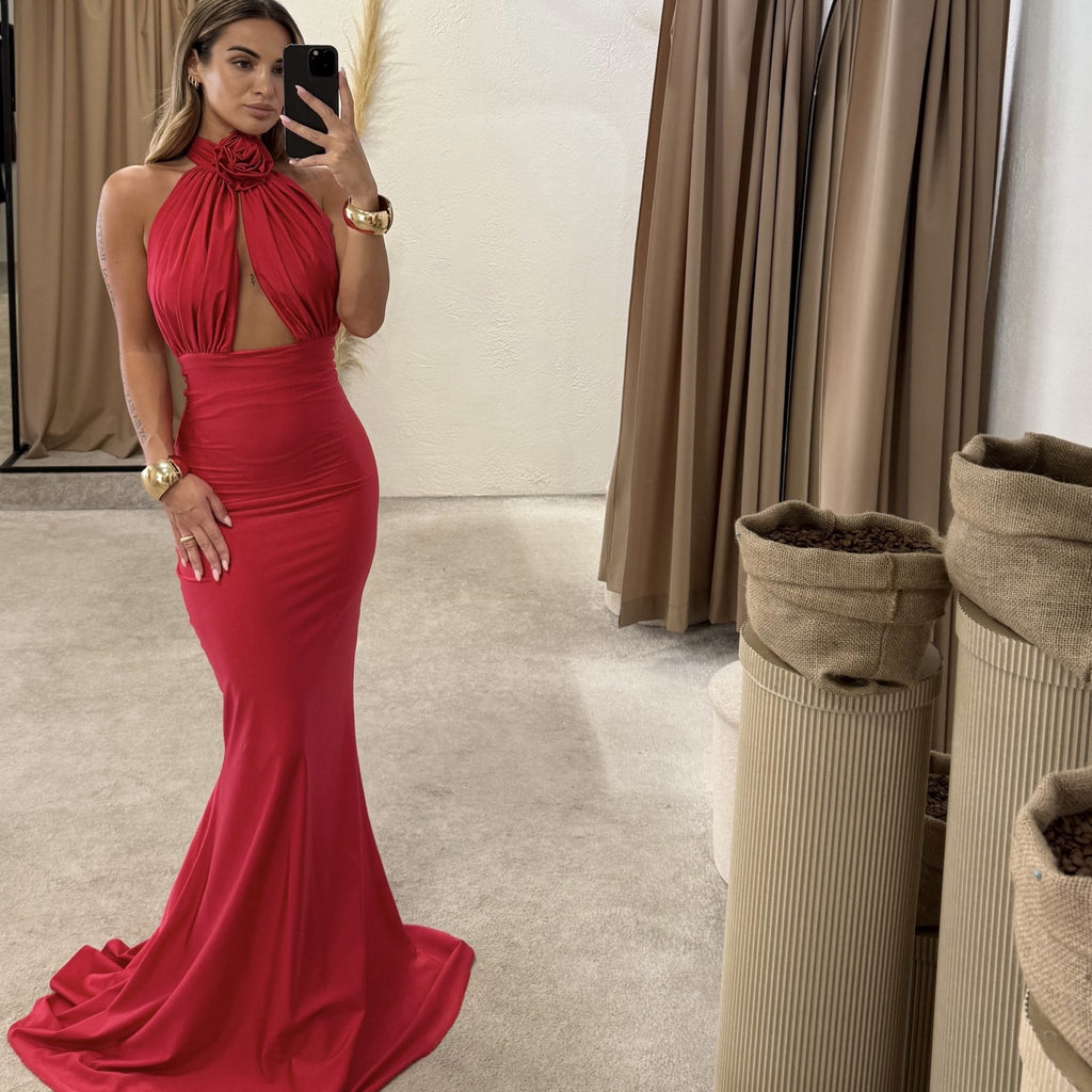 woman wearing red halter neck evening gown posing in dressing room woman wearing red halter neck evening gown posing in dressing room